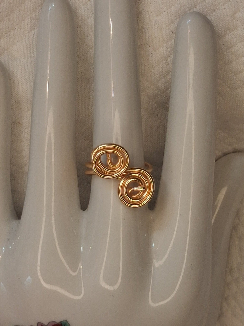 Gold 5 adjustable wire ring with two closely paired offset round spirals, displayed on a white ceramic jewelry hand.