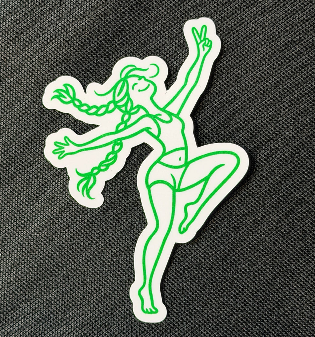 Dancing BeaGrl vinyl sticker on black fabric, with bright green line art, flying braids, a raised peace sign, and a white die cut border.