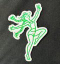 Dancing BeaGrl vinyl sticker on black fabric, with bright green line art, flying braids, a raised peace sign, and a white die cut border.